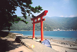 A torii gate stands beside the beach at the harbor in Heda