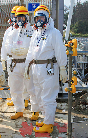 Prime Minister Yoshihiko Noda, wearing a white protective suit, pauses for the photographers at the Fukushima No. 1 nuclear plant Sunday