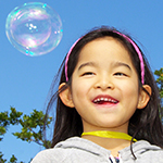 A happy child at the bubble-blowing machine, Okinawa Pref.